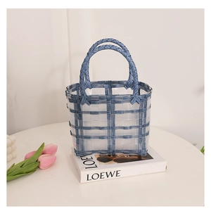 Close-up of blue and white checkered woven basket bag with round handles for beach vacation