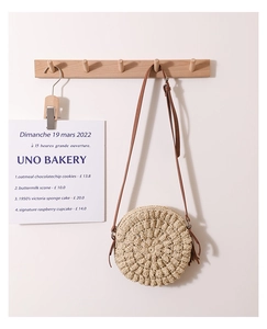 Macro detail of round straw crossbody bag with fine spiral weaving and leather strap