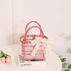 Pink and white woven jelly basket bag with lace bow accessory for summer beach holidays