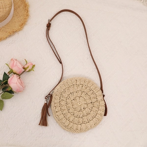 Handmade circular straw crossbody bag with brown leather strap and tassel for beach summer