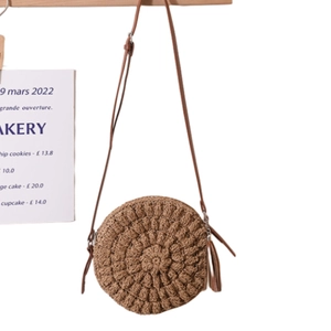 Handmade circular straw crossbody bag in dark brown with tassel and thin leather strap
