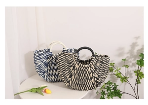 Detailed view of hand-woven straw bags in fan-shaped design with round top handles