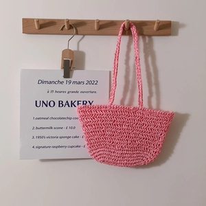 Pink hand-woven straw shoulder bag with minimalist hollow pattern for summer beach vacations