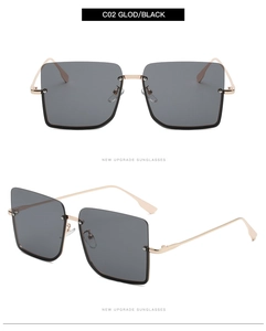 Detail view of gold metal half-frame sunglasses with gradient black square lenses