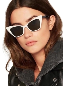 Side view of white cat-eye sunglasses with thick frames and black temples on a female model
