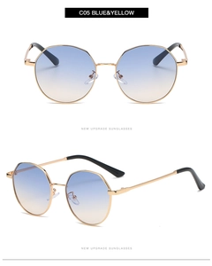 Close-up of blue and yellow gradient lenses with slim gold metal frame on sunglasses