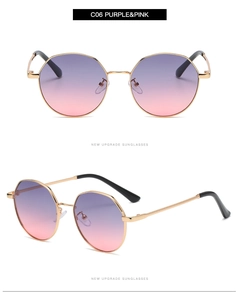 Detail view of round gradient purple and pink lenses with gold metal frames and black tips