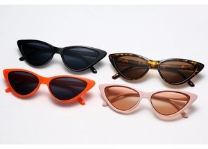 Détail de lunettes de soleil œil de chat rétro en noir, écaille, orange et rose chic