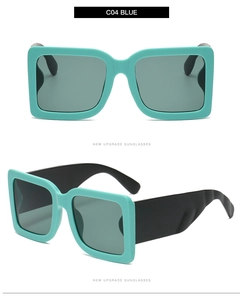 Detail view of bold square sunglasses with teal frames and thick black temples