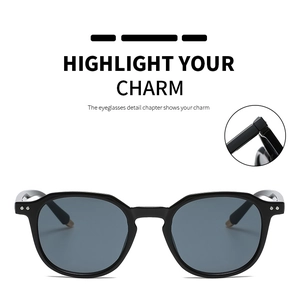 Detail of square black sunglasses showing silver rivets and golden temple tips