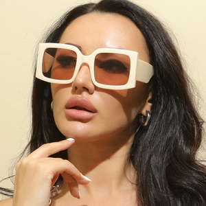 Close-up of cream square frame sunglasses with translucent orange lenses in retro style