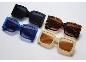 Flat lay of oversized square sunglasses in black, tortoiseshell, blue and cream beige frames
