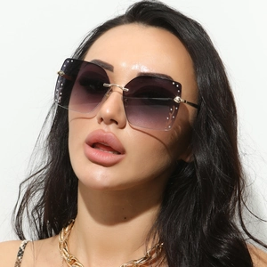 Close-up of oversized rimless square sunglasses with purple gradient lenses and rhinestones