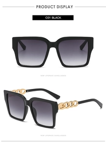 Detail view of square oversized sunglasses featuring gold metal chain temples and black frame