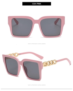 Detail of pink square frame sunglasses with golden metal chain temples and grey lenses