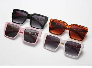 Detail view of square oversized sunglasses with decorative metal chain temples in four colors