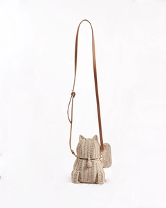 Detailed texture of hand-woven cat-shaped straw bag with adjustable brown strap