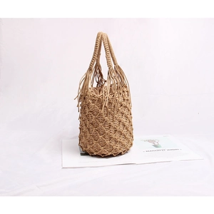 Détail d'un sac seau en paille tissée avec motif résille et doublure à cordon marron