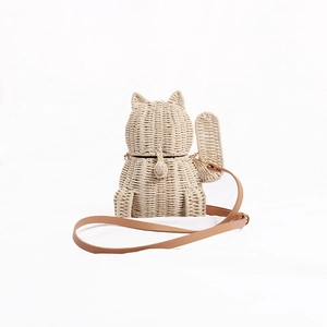 Detailed view of woven Lucky Cat straw crossbody bag with adjustable brown shoulder strap