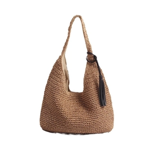 Brown woven straw hobo shoulder bag with black fringe tassel for beach vacations