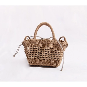 Detailed view of hollow straw tote bag with linen drawstring lining and woven handles