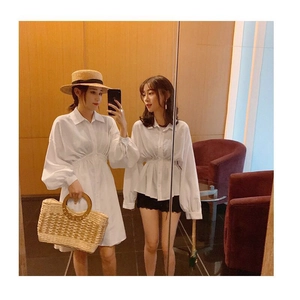 Mirror selfie showing a long white cotton shirt dress with waist pleats in a rustic style