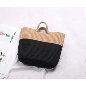 Handcrafted woven straw beach tote bag with a two-tone beige and black design