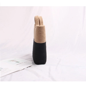 Two-tone woven straw tote bag with black and beige contrast and thick handles