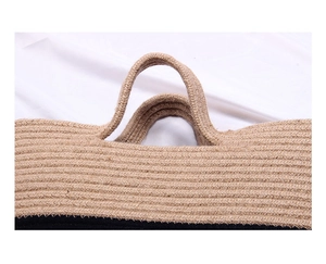 Détail du cabas en paille tissé main avec coutures noires et beige et poignée robuste