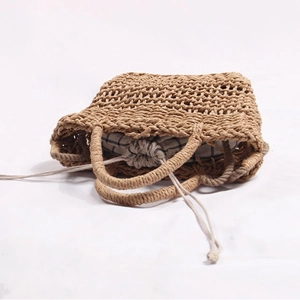 Handmade hollow straw tote bag with black and white checkered drawstring lining for beach vacations