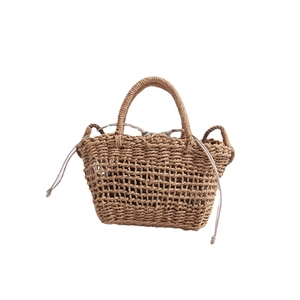 Handmade straw woven crossbody bag with round handles and drawstring inner pouch for beach