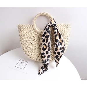 Close-up of semi-circle straw bag with leopard print scarf and round handle