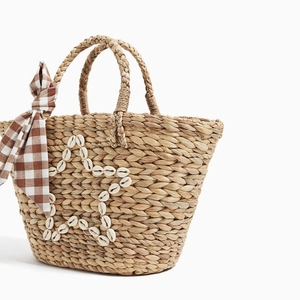 Handmade straw beach tote bag featuring shell star embroidery and a checkered bow accent