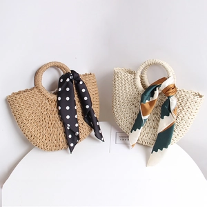 Detailed view of handmade semi-circular straw bags with decorative fashion silk scarves