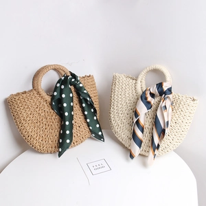 Detailed texture of handmade straw bags with decorative silk scarves in khaki and cream
