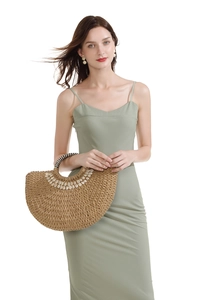 Close-up of semi-circular straw woven bag with white shells and striped handles