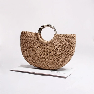Macro shot of semi-circle straw handbag with black and white striped round handles