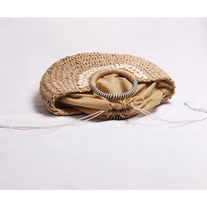 Handmade straw handbag with shell accents and drawstring liner for beach vacations