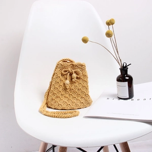 Handmade crochet crossbody bucket bag in mustard yellow featuring drawstring closure