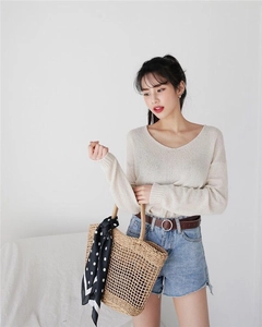 Detailed close-up of a cream v-neck knitted sweater with a lightweight breathable texture