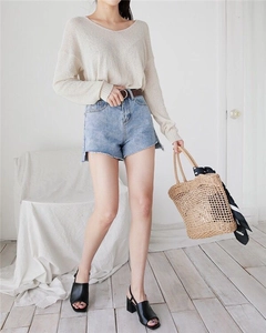 Detail of hand-woven straw bucket bag with polka dot scarf and summer vacation outfit