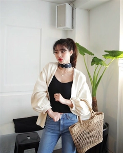 Close-up of beige knit cardigan featuring hollow lace crochet trim and puff sleeves