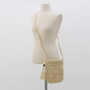 Straw crossbody bag with hollow flower weave, tassels and wooden beads for beach vacations