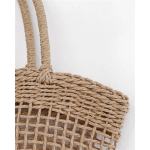 Detailed close-up showing the hollow weave pattern and texture of the straw beach bag