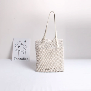 Minimalist cream woven hollow tote bag with leather straps for summer beach vacations
