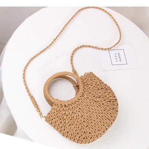 Detail of handmade straw woven bag with circular handles and detachable shoulder strap