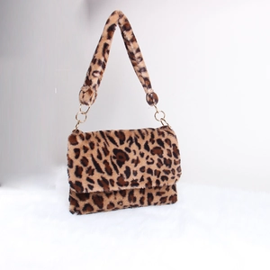 Detail of leopard print plush handbag with soft faux fur texture and gold metal ring strap