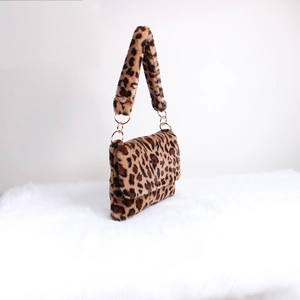 Detail view of leopard print plush bag with gold metal rings and faux fur texture
