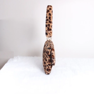 Macro shot of fluffy leopard print plush bag featuring elegant gold metal ring connectors