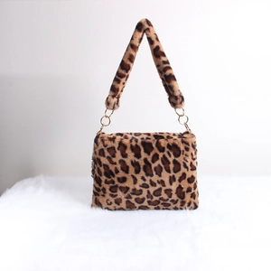 Detail of leopard print faux fur handbag with golden metal rings and plush texture